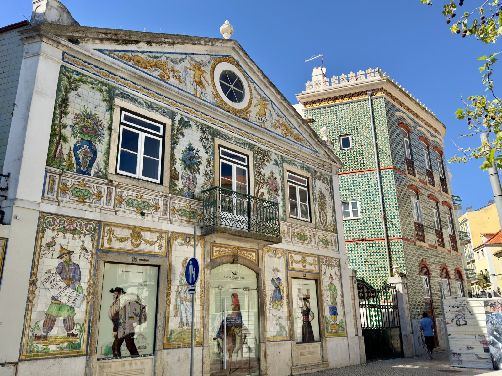 A building covered in hand-painted tiles of figures, garden urns and cherubs, dated 1865, in Largo do Intendente